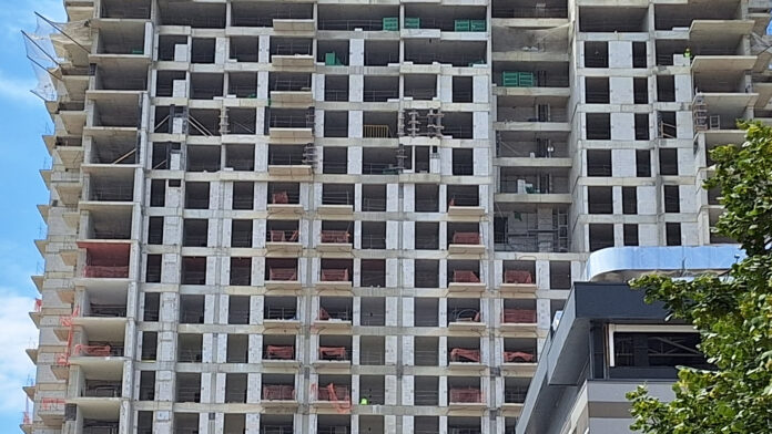 zgrada vo gradba, gradiliste, gradezni rabotnici foto kolegium