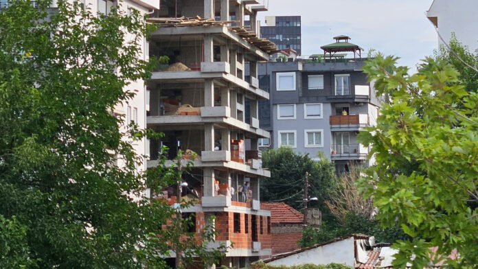 zgrada vo gradba, gradiliste, gradezni rabotnici foto kolegium