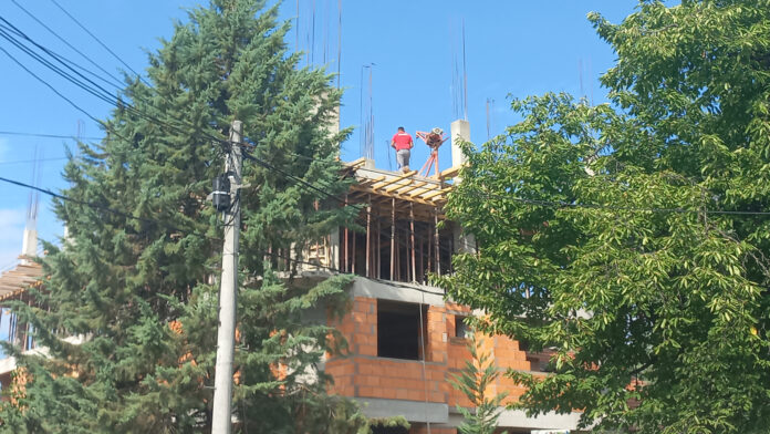 zgrada vo gradba, gradiliste, gradezni rabotnici foto kolegium